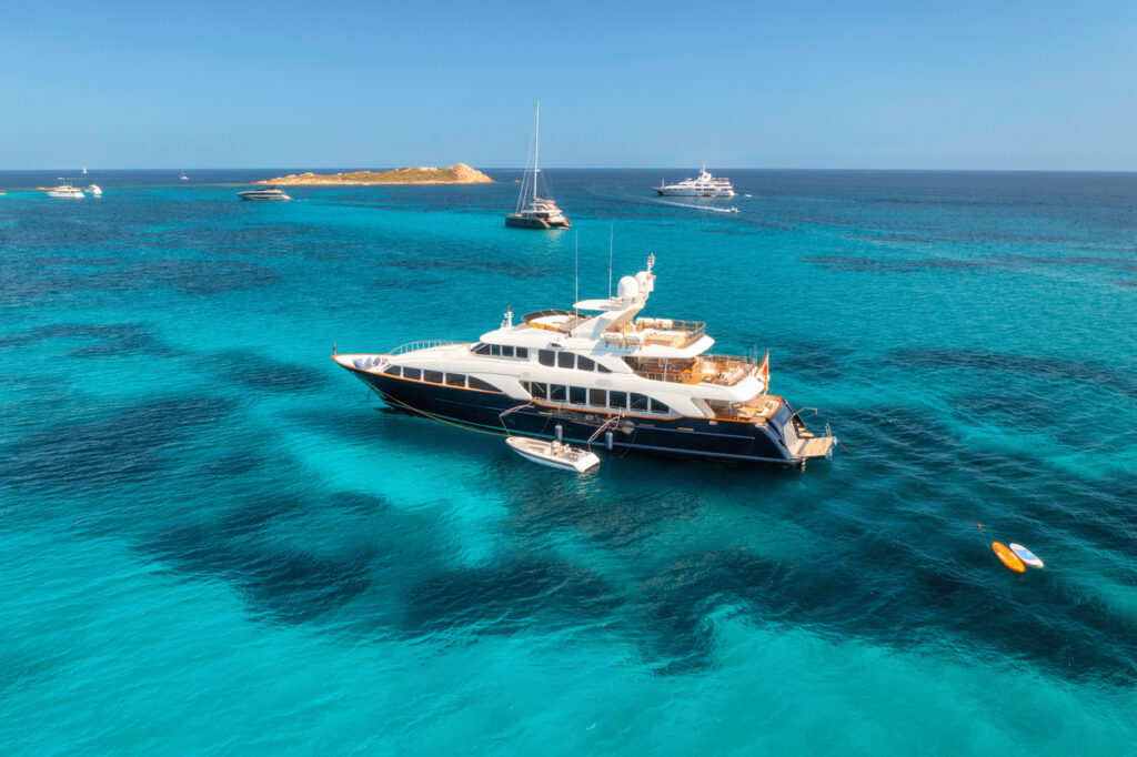 Yacht insurance rates: Aerial view of luxury yacht on blue sea at sunny day in summer.